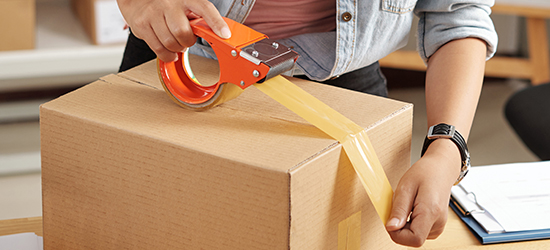 Customer taping a box to prepare for shipping.